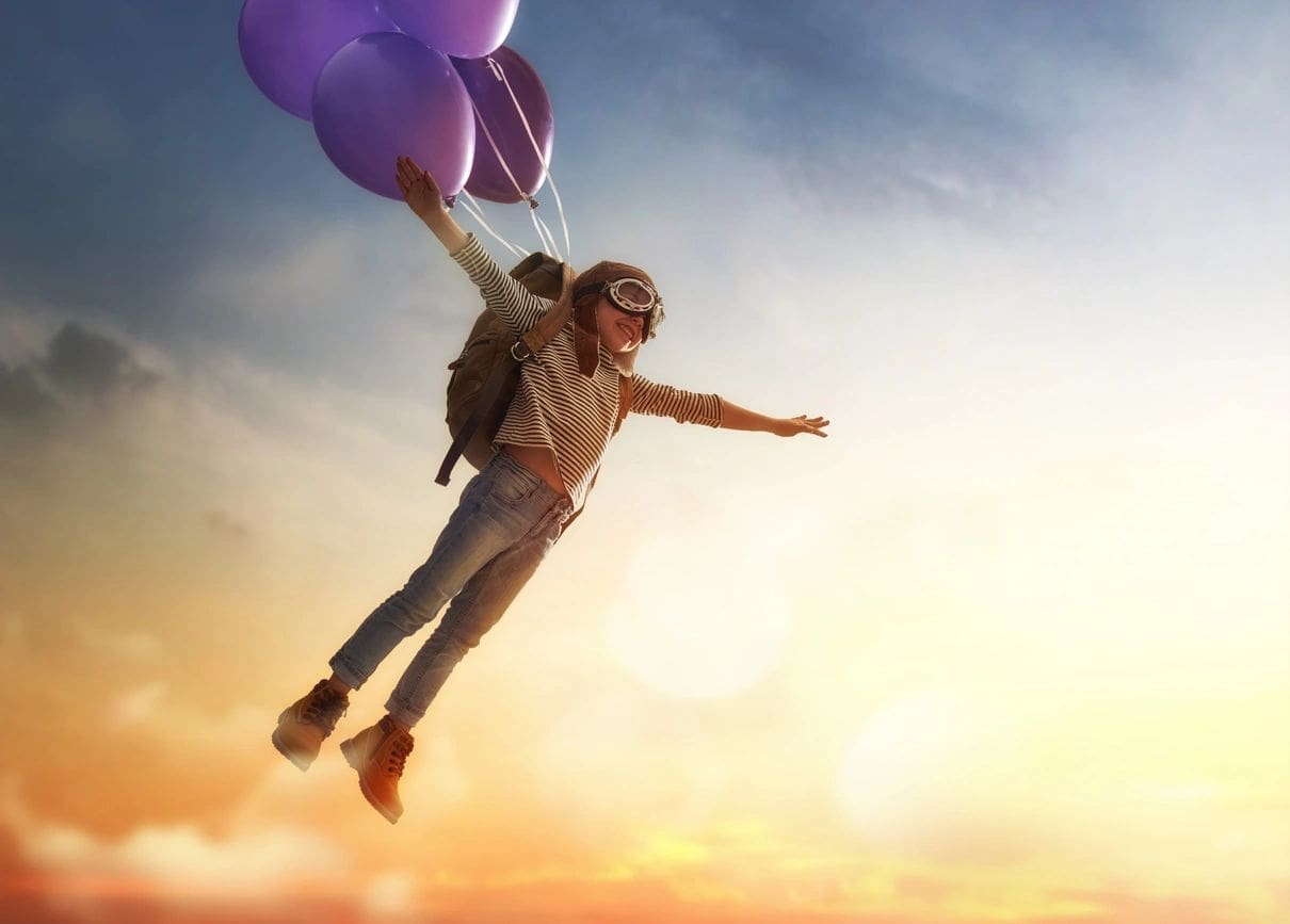 A person flying with balloons in the air.